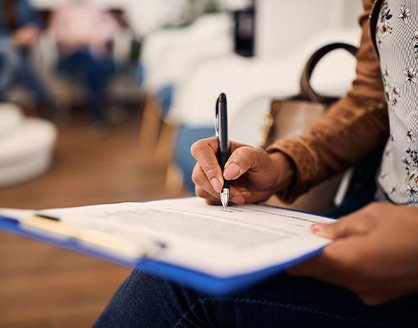 Patient in Arlington filling out paperwork for dental implants