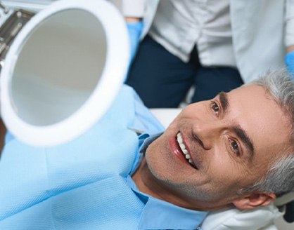 a patient checking his smile with a mirror